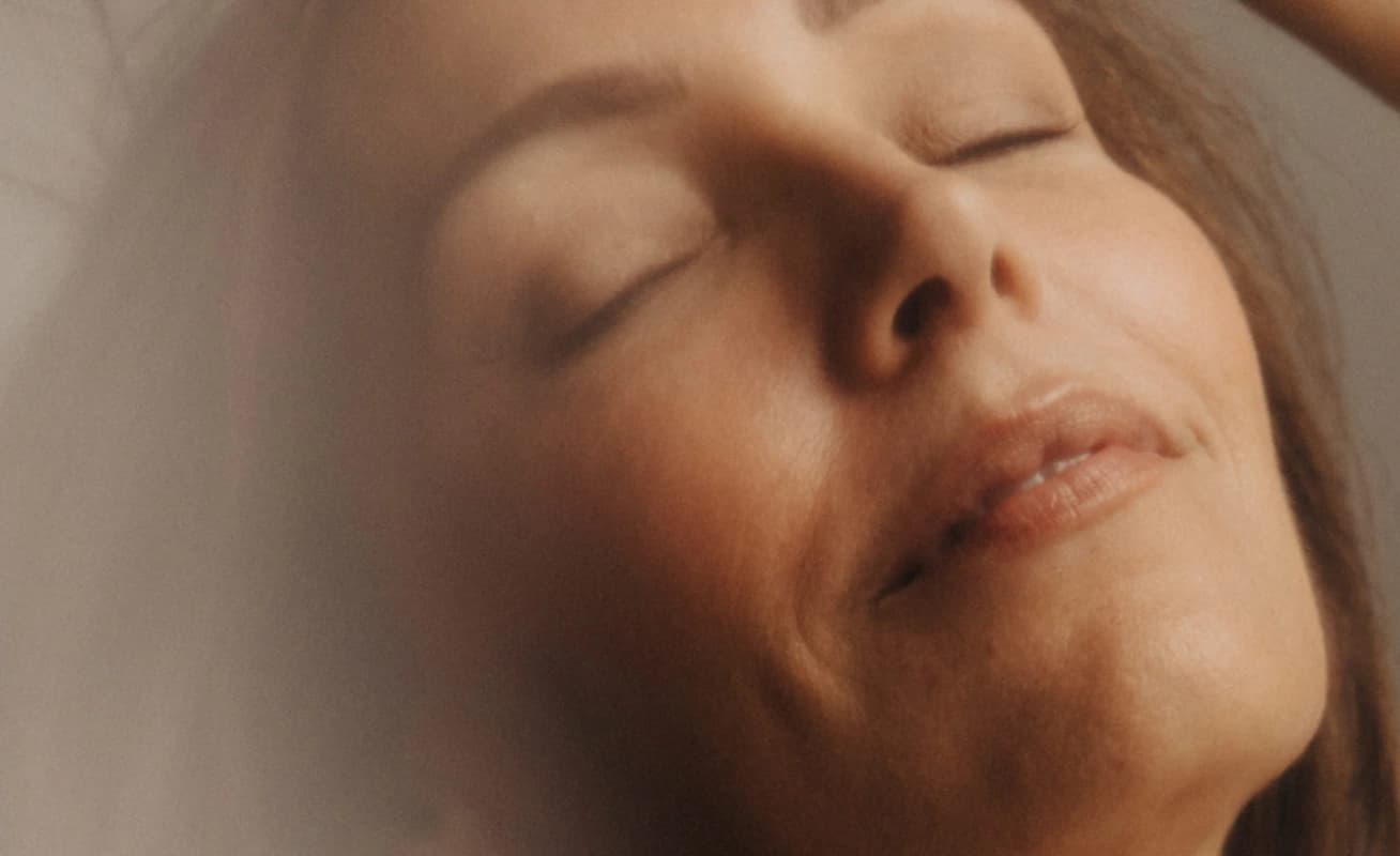 Woman lying down with eyes closed, relaxing during a spa treatment