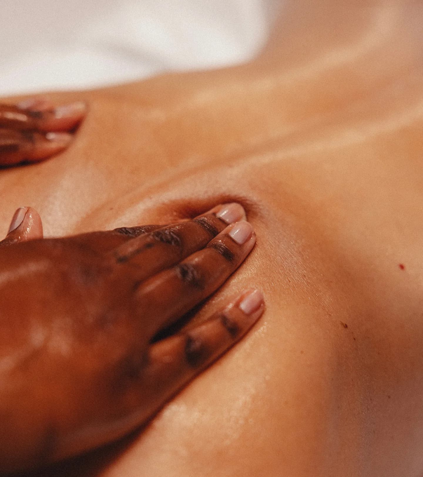 Therapist providing a gentle oncology massage to a client in a relaxed setting.