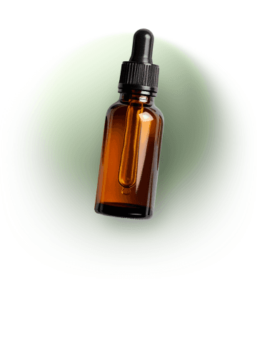 Amber glass dropper bottle of essential oil used for aromatherapy on a soft green background