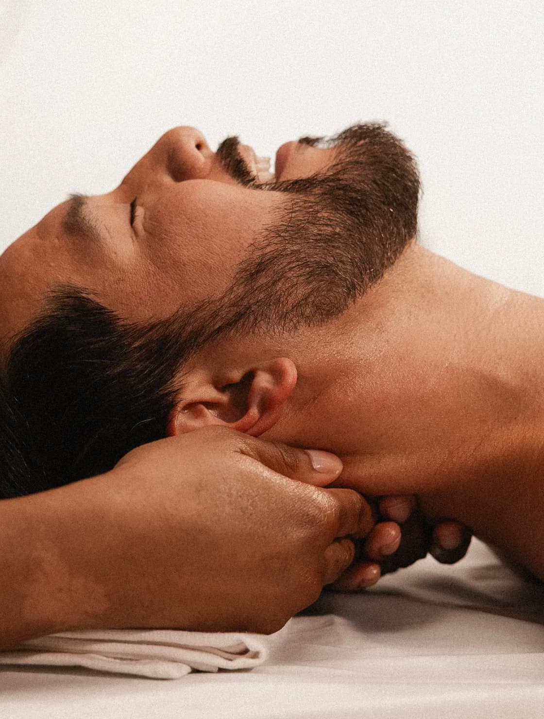 Man with eyes closed, smiling, and visibly deeply relaxed while receiving a classic massage